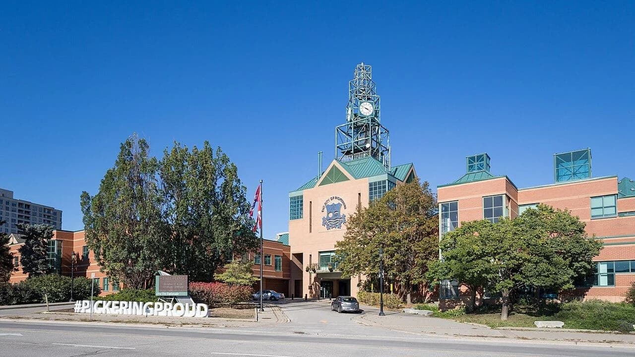 Exterior of Pickering City Hall on a clear October day, clock tower and brick facade, no people