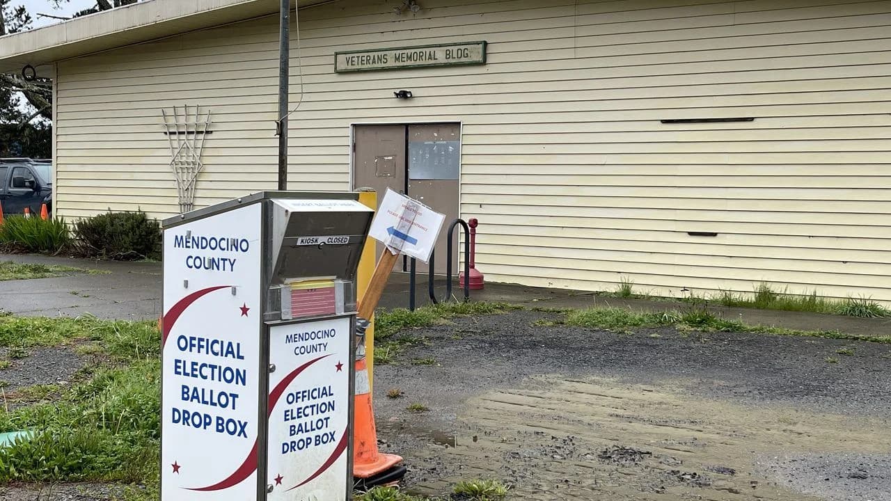 Official election ballot drop box standing outside a public building; no people visible