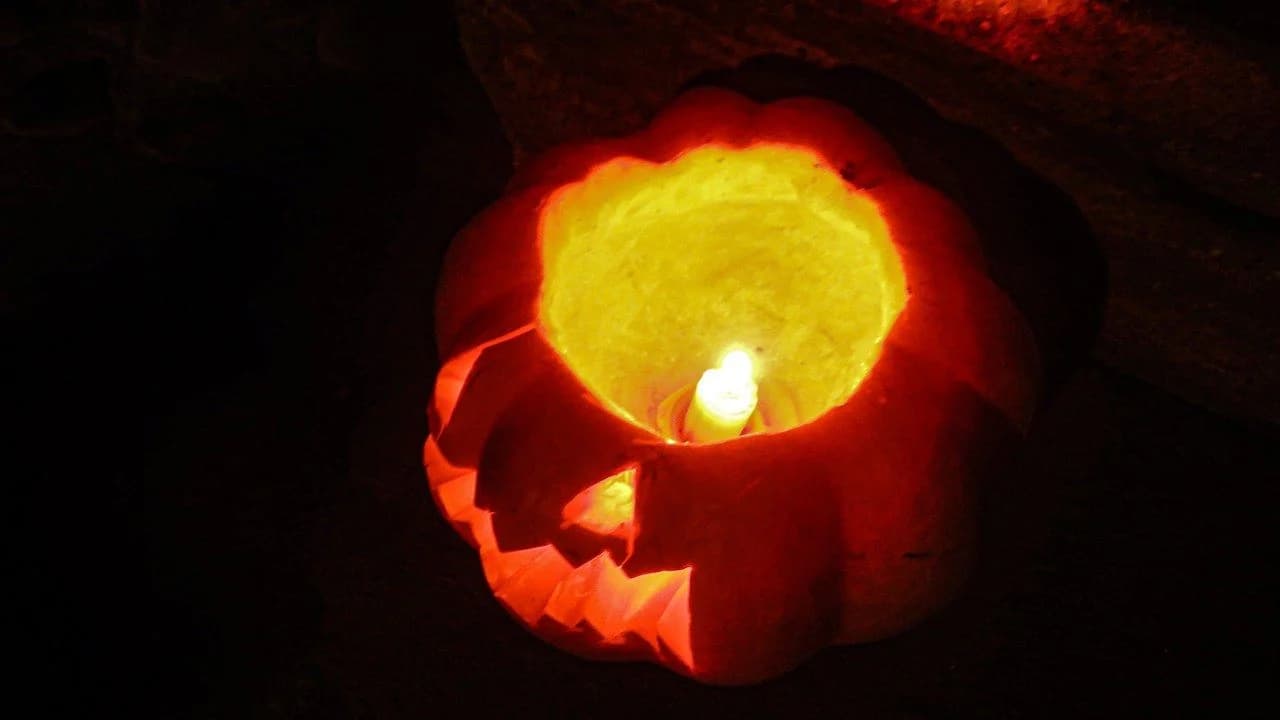 A lit jack-o'-lantern glowing at night; no people present
