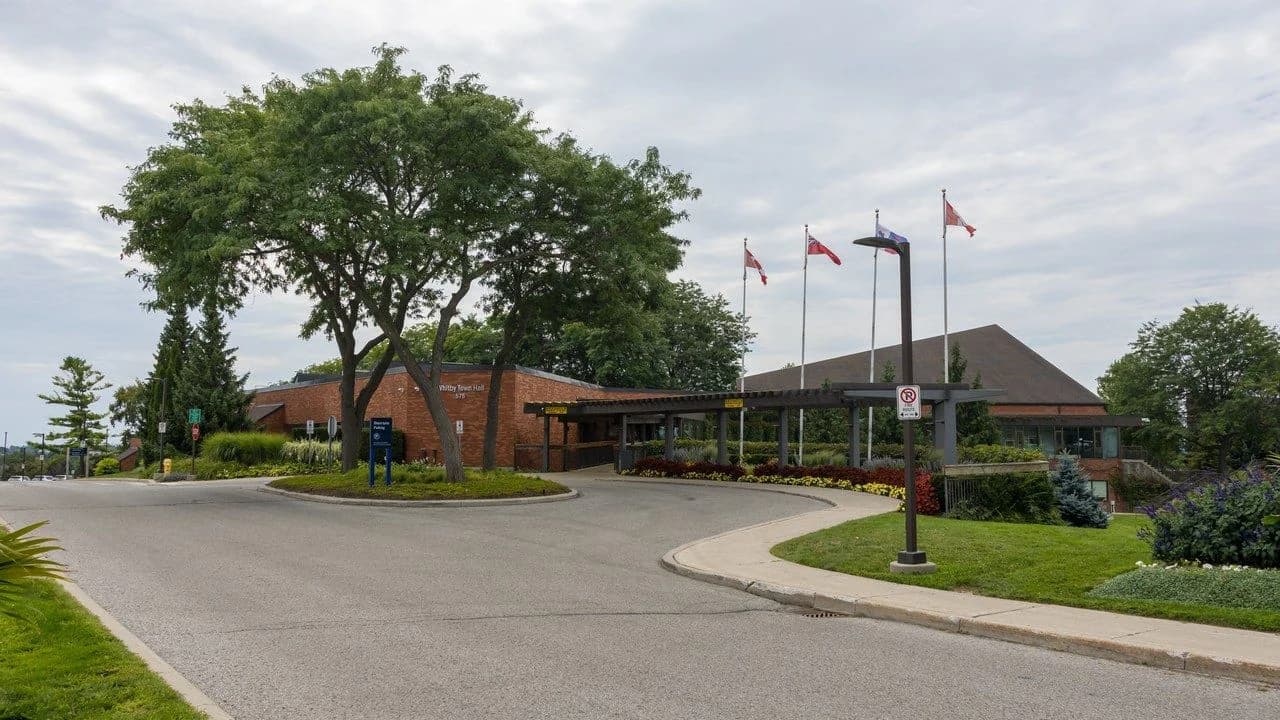Daytime exterior of Whitby Town Hall on Rossland Road in Whitby, Ontario; no people visible.