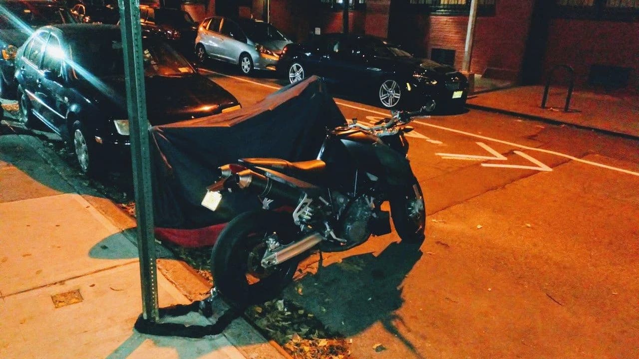 Parked motorcycles on a street at night; no people visible