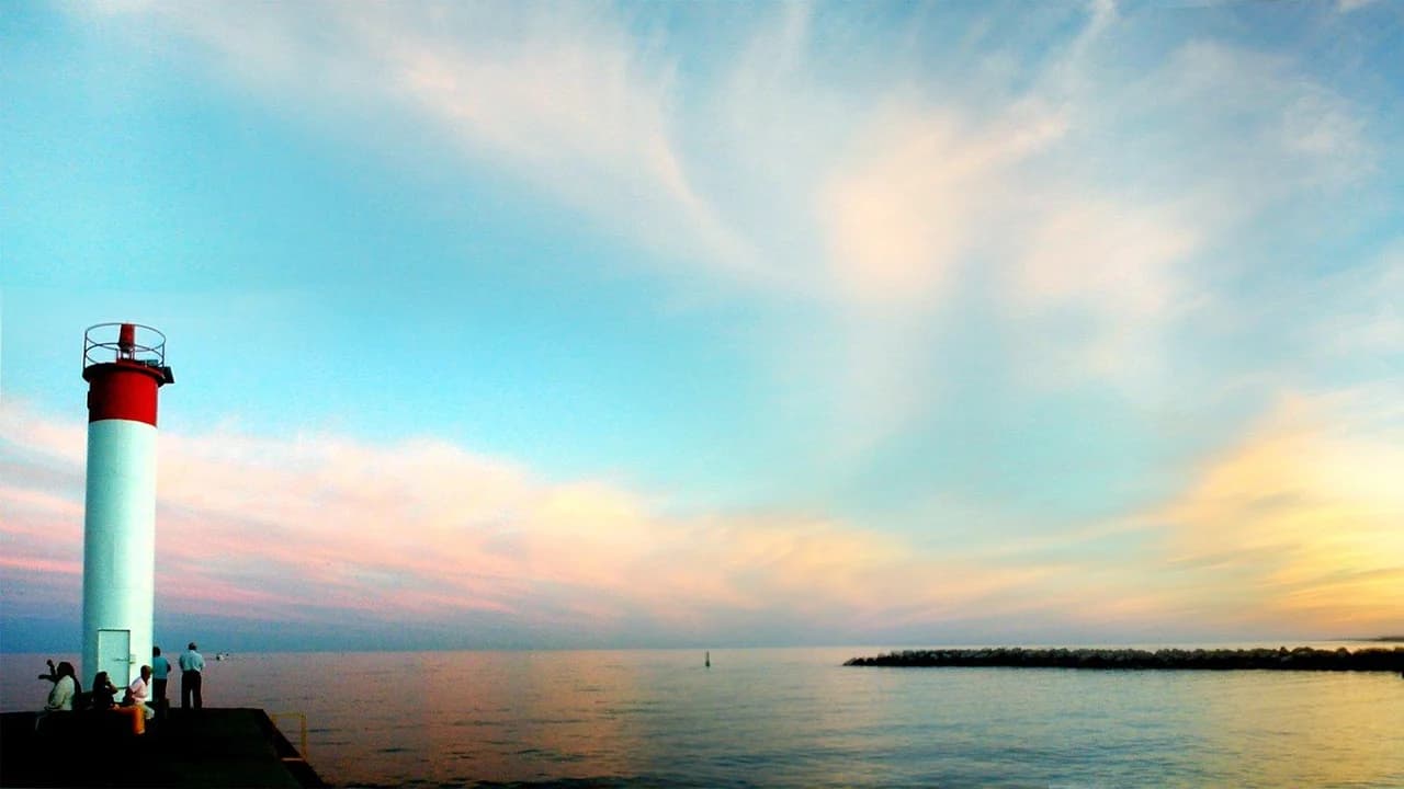 Whitby Harbour lighthouse and breakwater at sunset on Lake Ontario; no identifiable people.